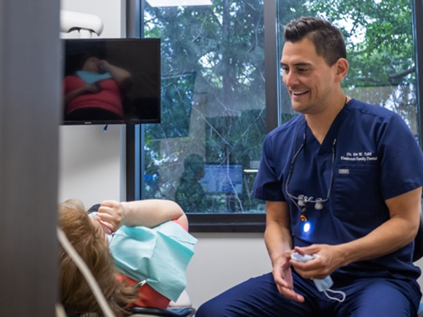 Dentist talking with a patient in the treatment chair