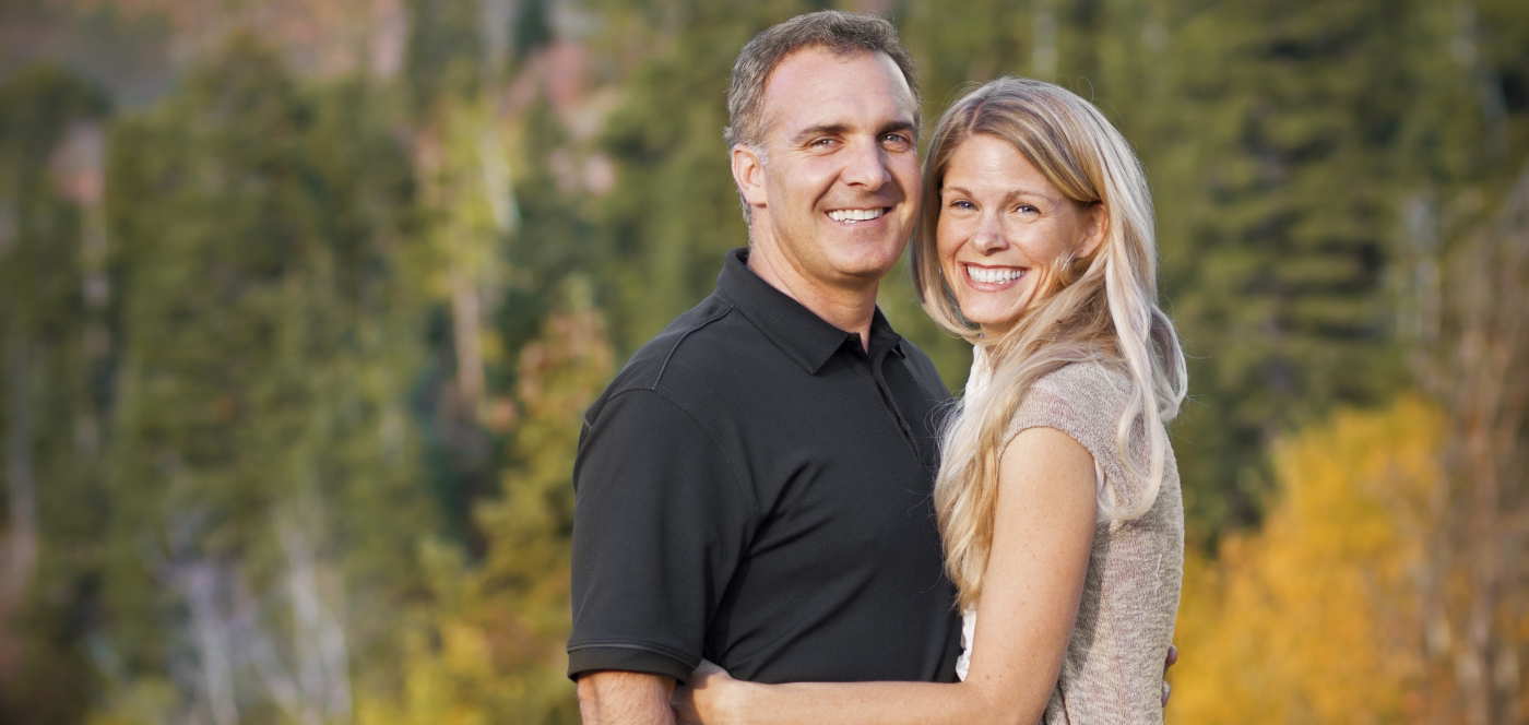 Man and woman grinning outdoors with dental implants in Wauwatosa