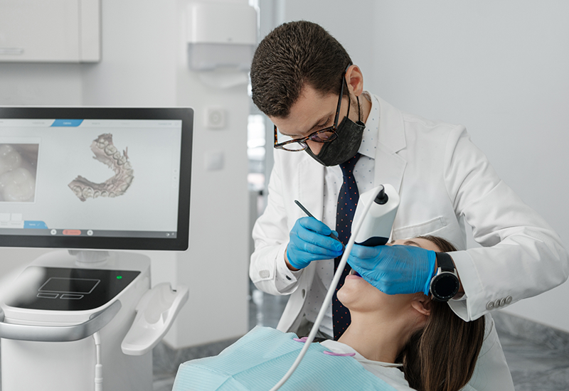 Dentist using a digital scanner to take impressions of a patients teeth