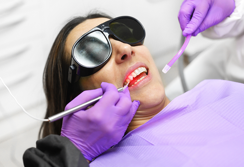 Woman in dental chair having her gums treated with a soft tissue laser