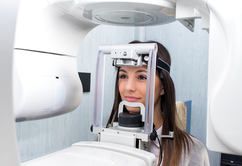 WOman having a cone beam C T scan taken of her mouth and jaw