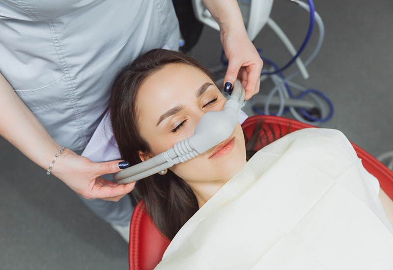 Dental patient with a nitrous oxide mask over her nose