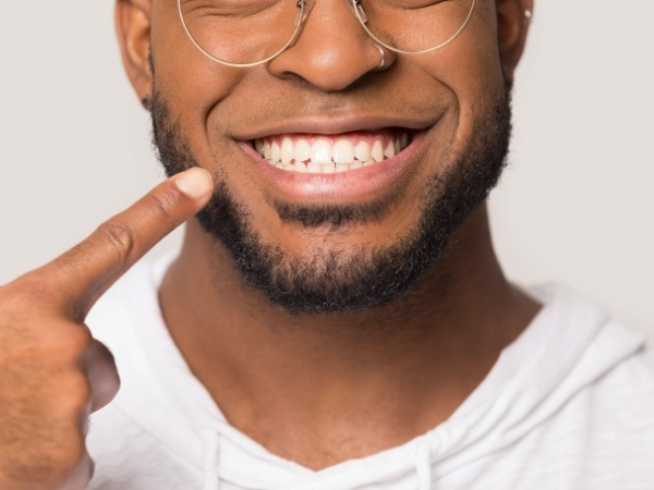 Close up of a man pointing to his smile