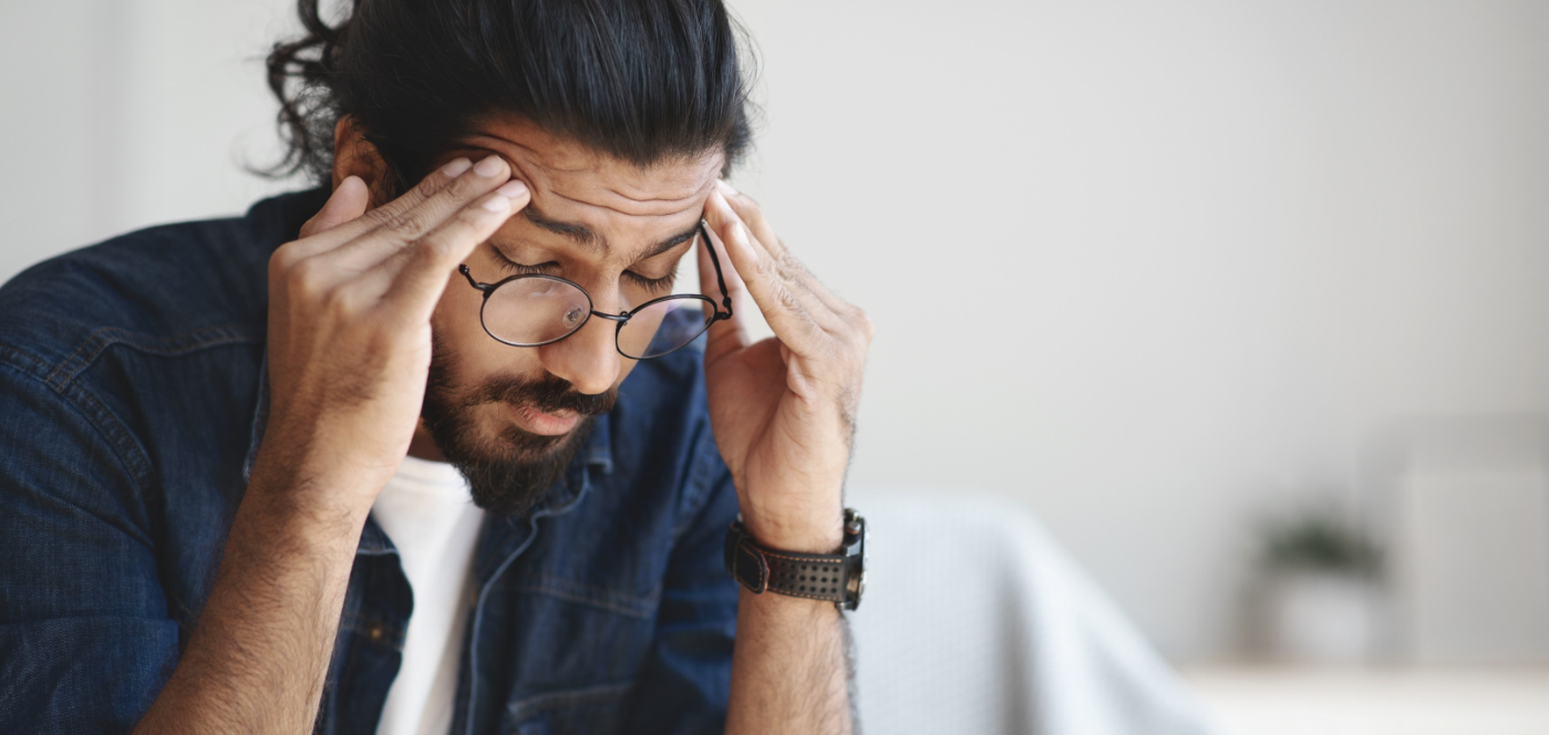 Man holding his temples in pain before headache and migraine treatment in Wauwatosa