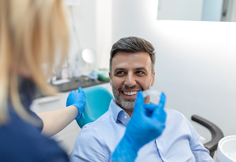 Dentist showing an Invisalign aligner to a patient