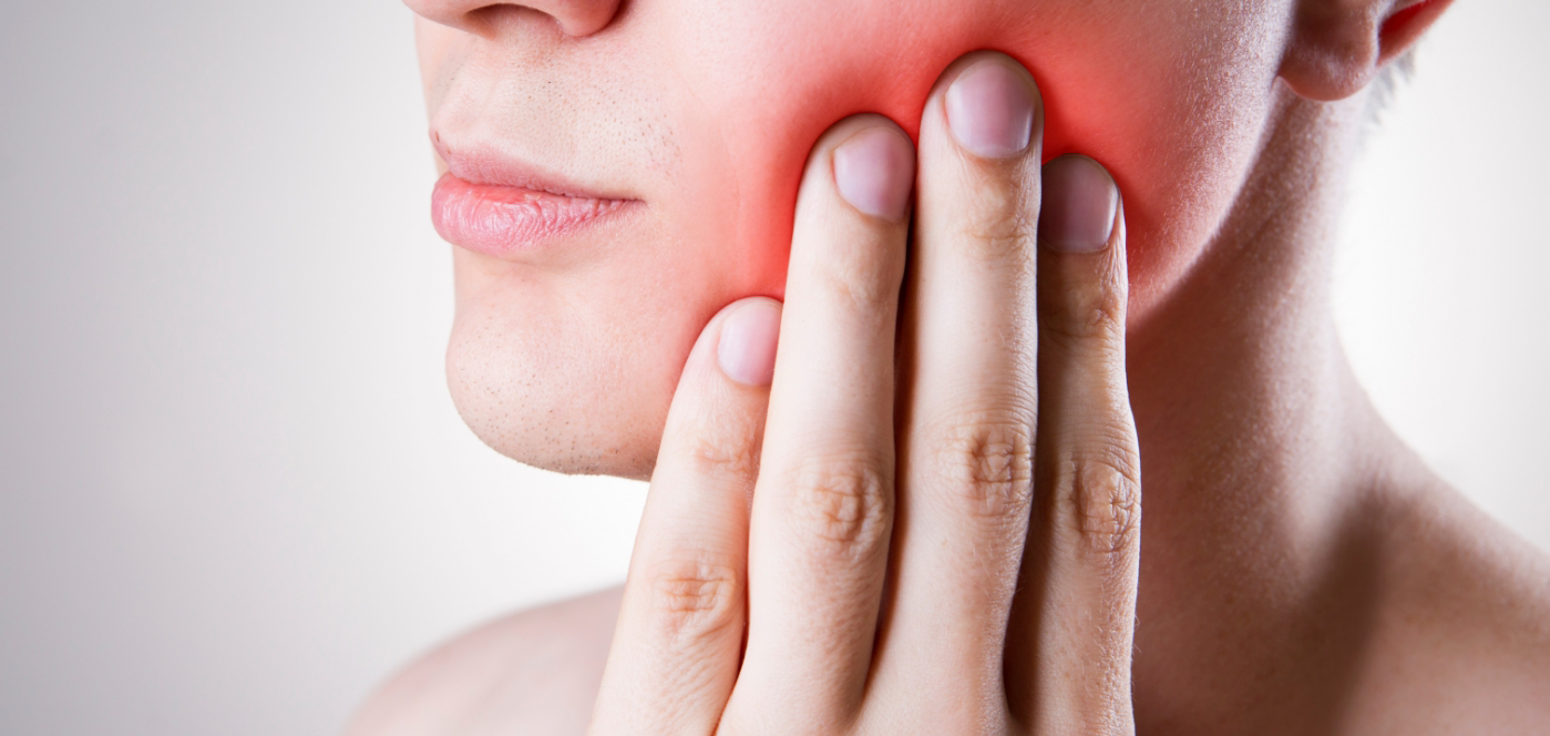 Close up of person holding the side of their jaw in pain