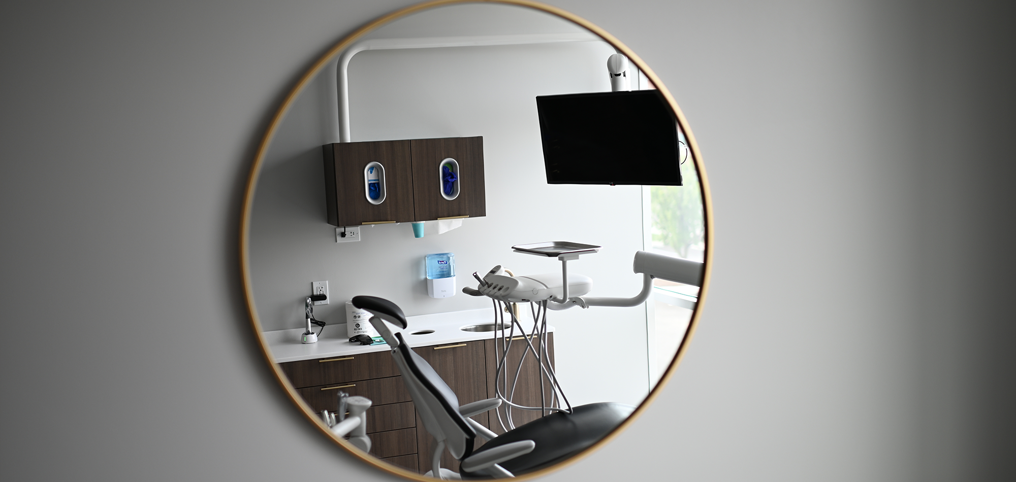 Mirror on wall showing reflection of dental treatment chair in Wauwatosa dental office