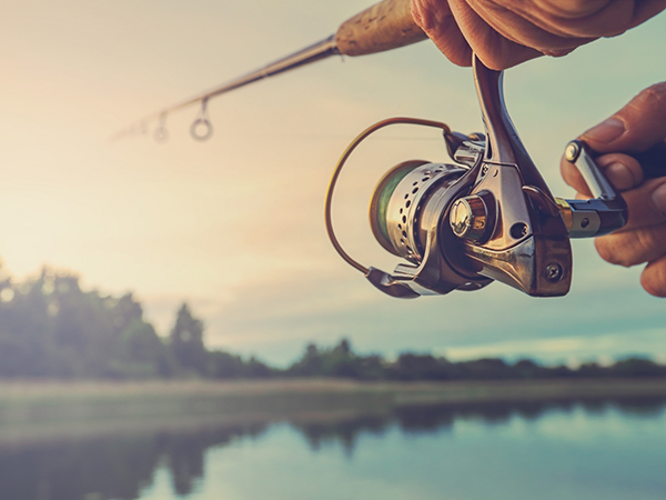 Person casting a fishing rod into a body of water