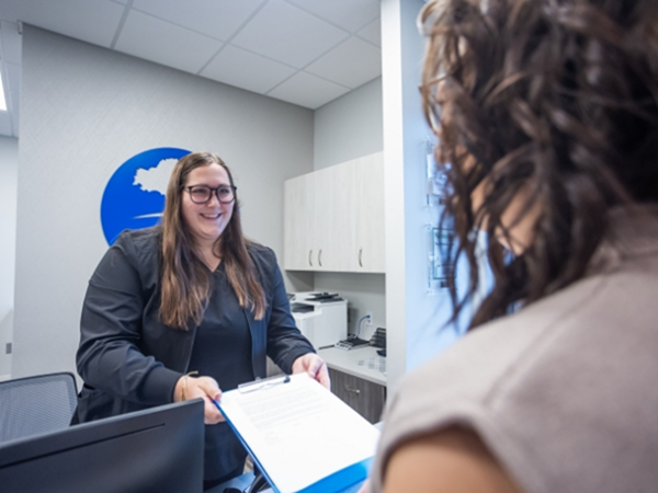 Dental team member handing a clipboard to a patient