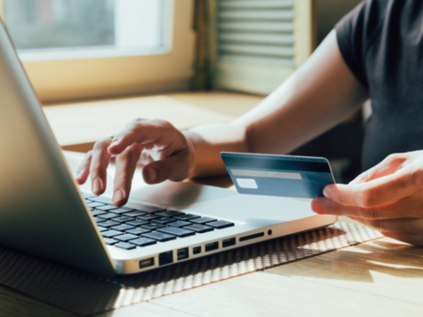 Person entering their credit card information onto a laptop