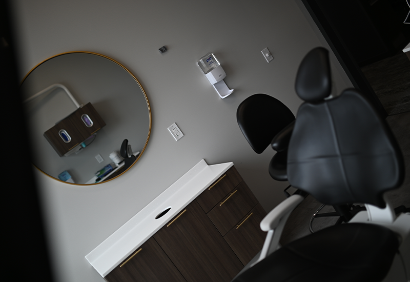 Dental chair with mirror on wall in background