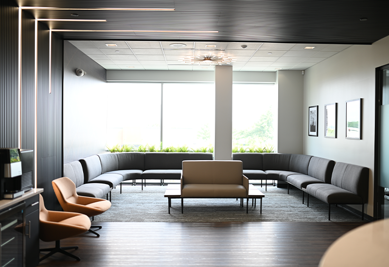 Reception area with black chairs along three of the four walls