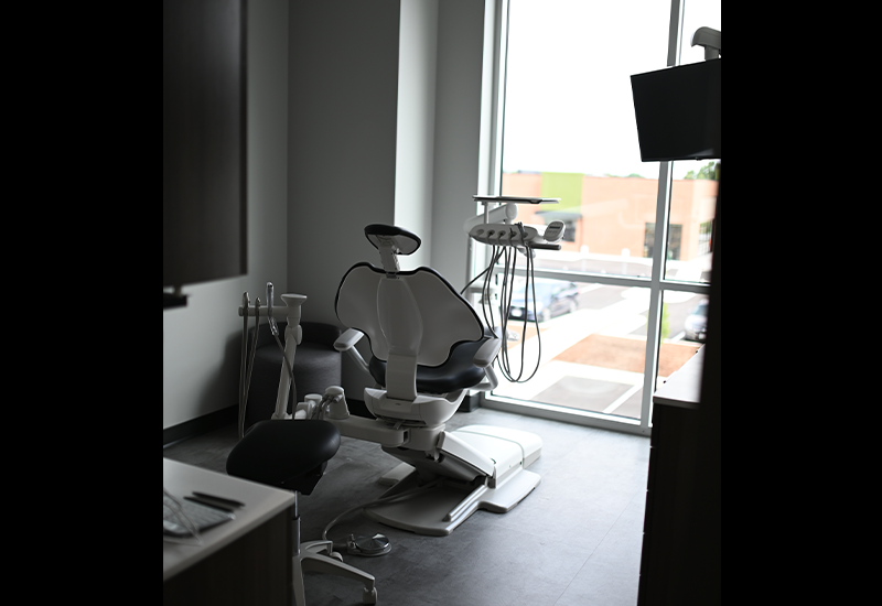 Empty dental treatment chair next to window