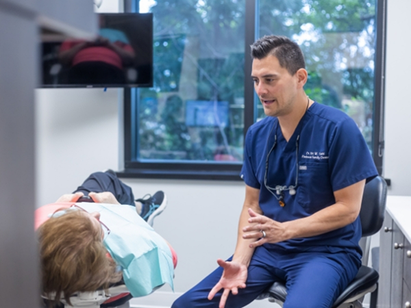 Dentist talking to a patient in the treatment chair