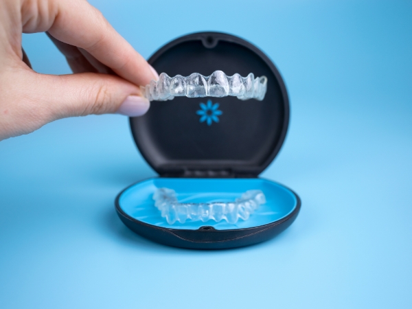 Person placing an Invisalign tray back in its storage case