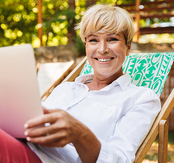 Woman sitting on chair outdoors and smiling