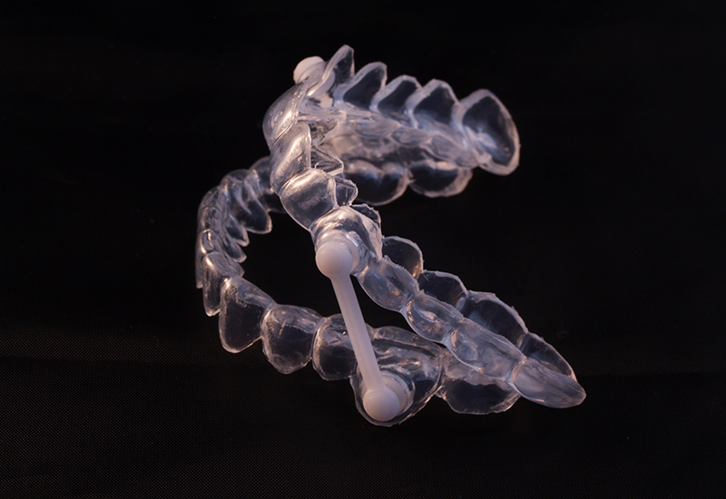 Clear oral appliance against black background