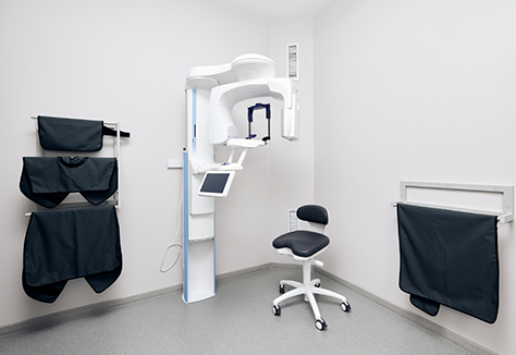 Cone beam C T scanner in corner of room with white walls