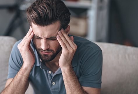 Man rubbing his temples in pain